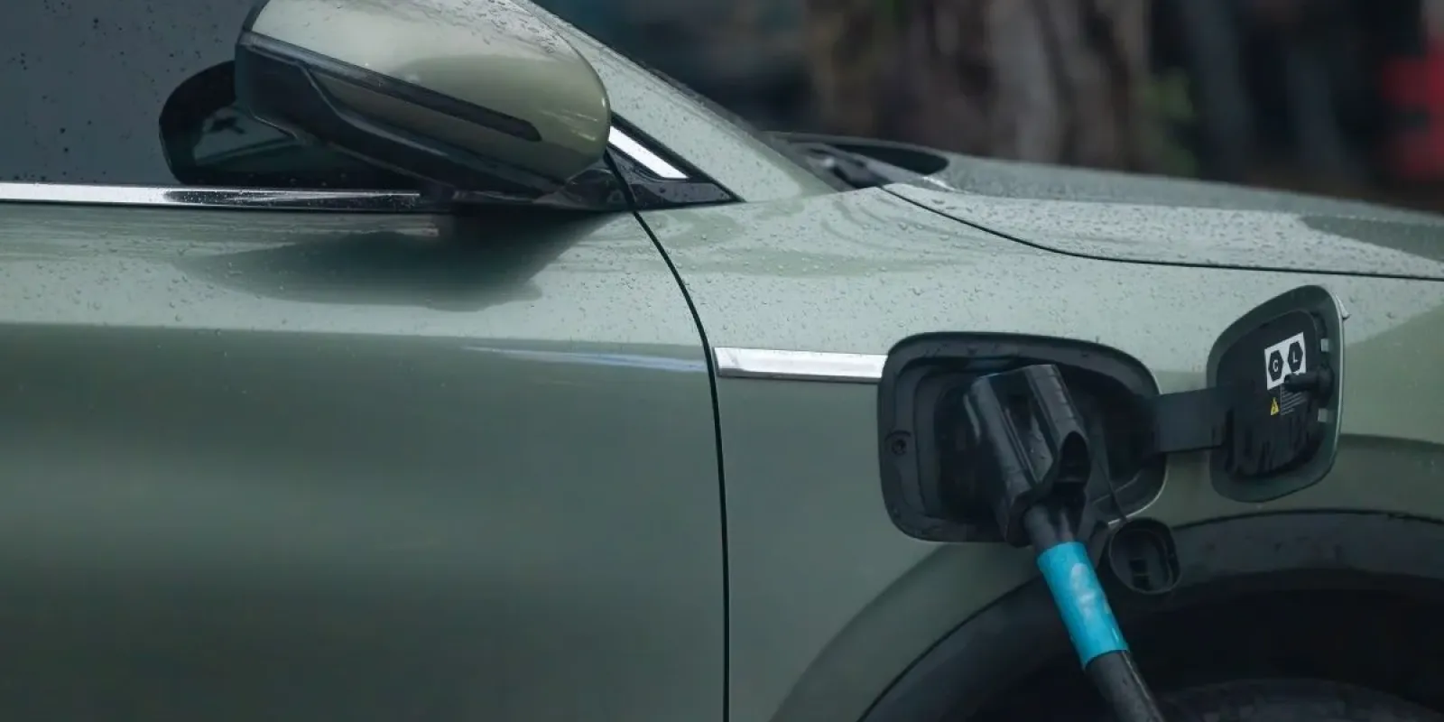 Vehículo eléctrico cargando en una estación EVORAA al anochecer